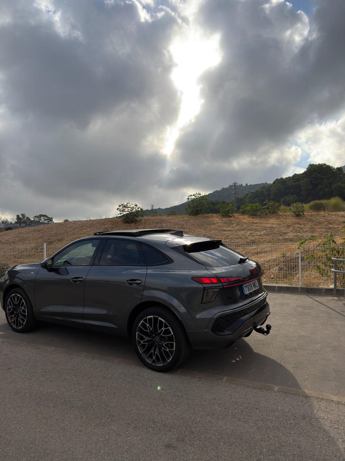 Audi Q3 Sportback gris, vista trasera con techo panorámico abierto